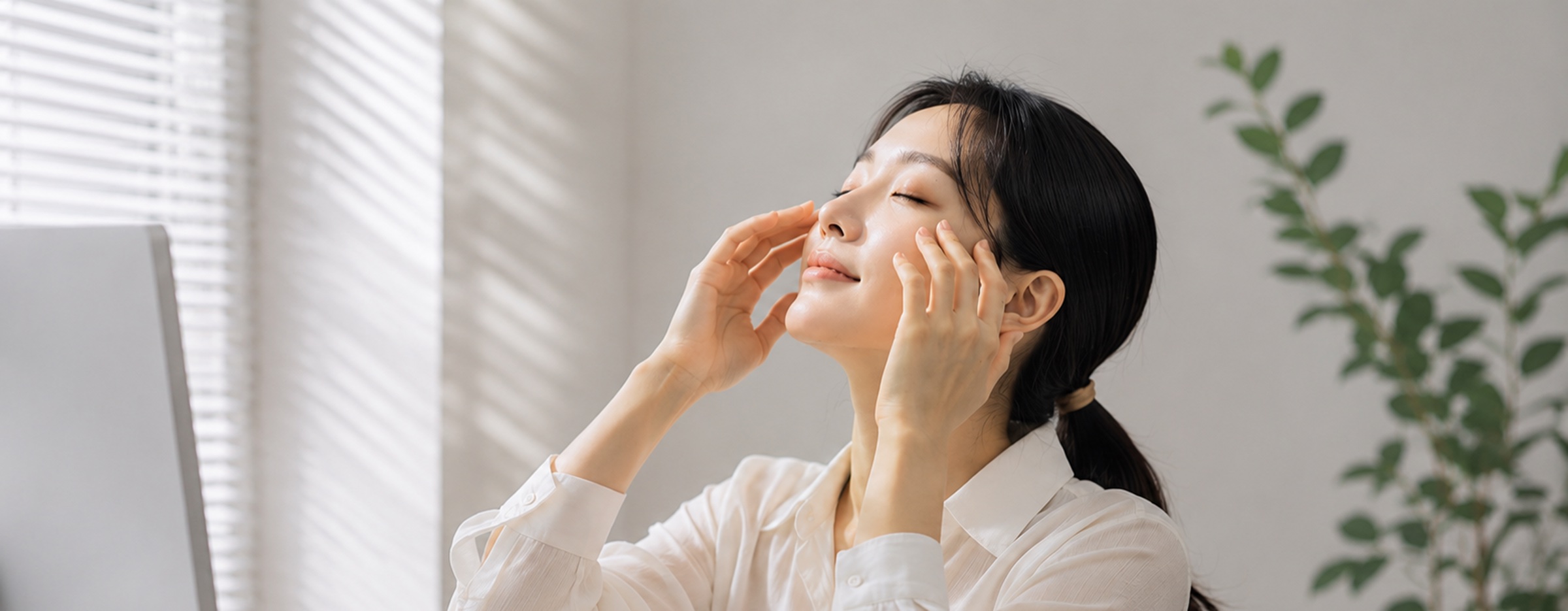 창가에서 눈가를 매만지는 여성